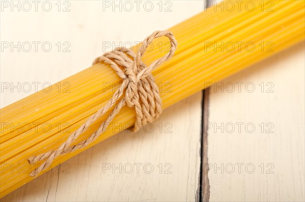 Italian pasta spaghetti tied with a rope on a rustic table