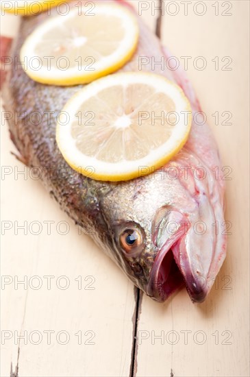 Fresh whole raw fish on a wooden table ready to cook