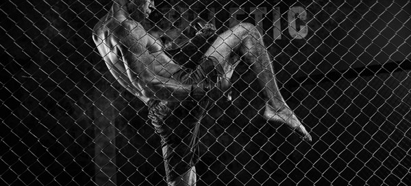 Black and white image of a man in a boxing cage. The concept of sports