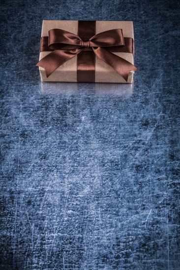 Wrapped present box on scratched metallic background holidays concept