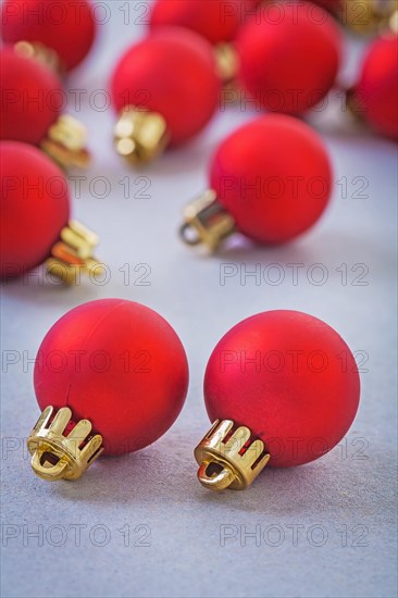 Composition of small red christmas baubles on grey background