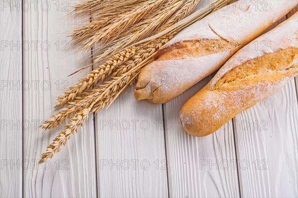 Composition two baguettes ears of wheat and rye on white boards Eating and drinking concept