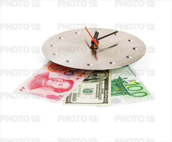 Currency bills on a stainless steel clock clock isolated on white back ground