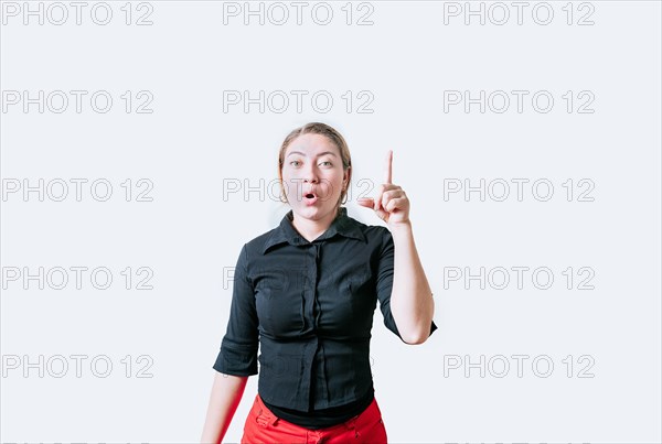 Beautiful surprised girl pointing a promotion up. Surprised young woman pointing a discount up