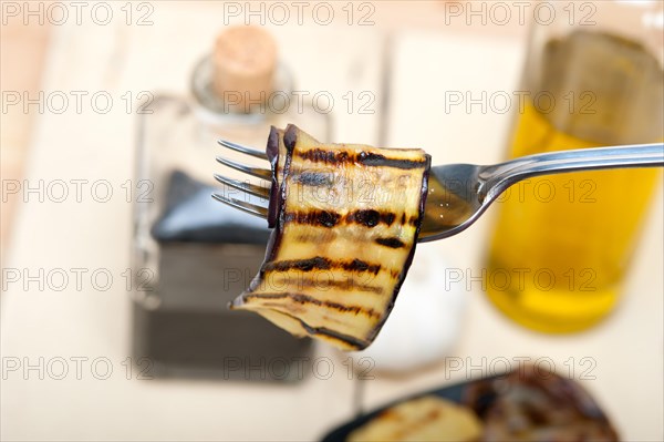 Grilled eggplant oubergine on a fork macro close up
