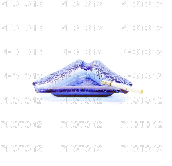 Blue murano glass ashtray with lighted cigarette isolated on white background