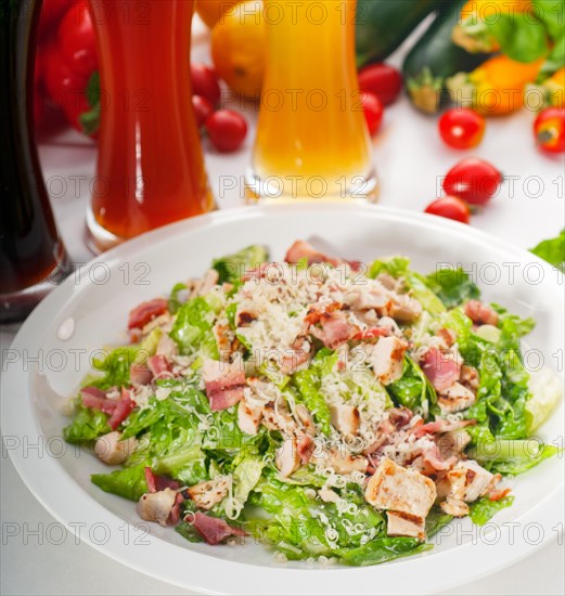 Fresh classic caesar salad with red and blonde beer on background