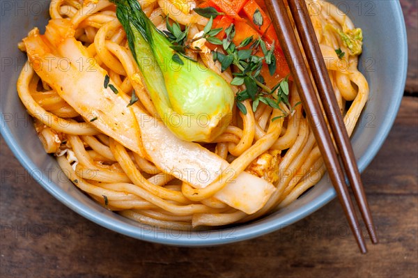 Hand pulled stretched Chinese ramen noodles on a bowl with chopstick