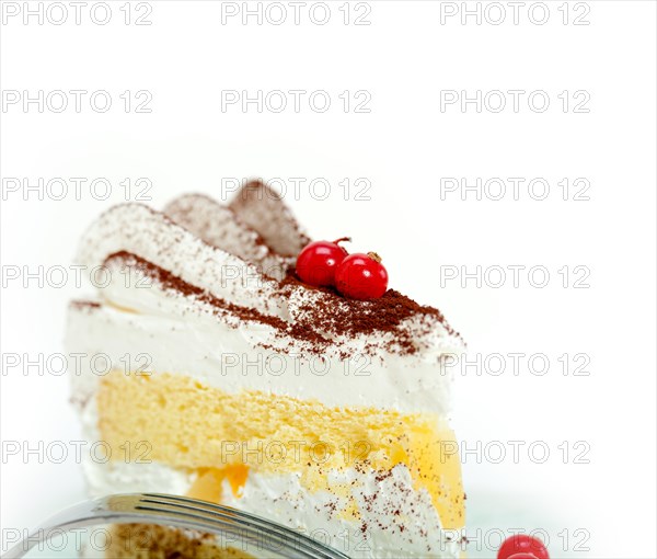 Fresh ribes and whipped cream dessert cake slice with cocoa powder on top