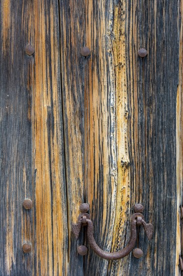 Old wooden door with aged metal door handle. Architectural textured background