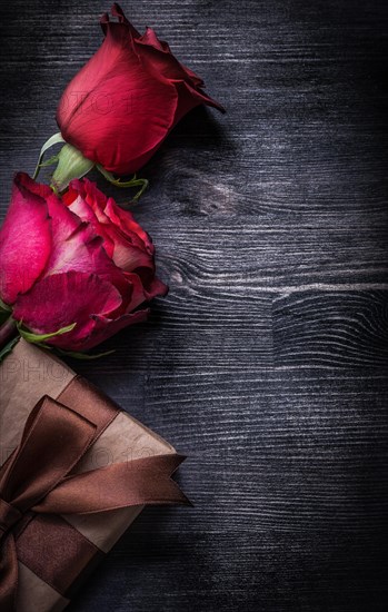 Bloomed scented rosebuds packed giftbox on wooden background holidays concept