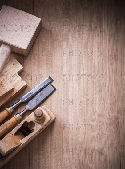 Vertical view of lump hammer shaving plane metal chisels and wooden planks on wood board construction concept