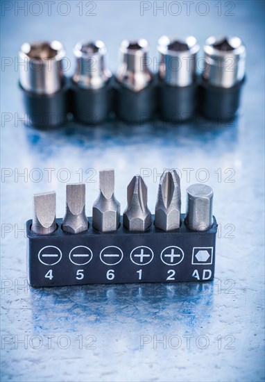 Collection of stainless steel screwdriver bits and torxes on metallic background construction concept