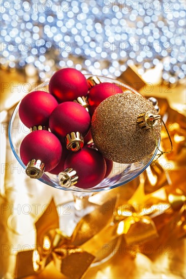 Golden and red Christmas baubles in a Martini wine glass