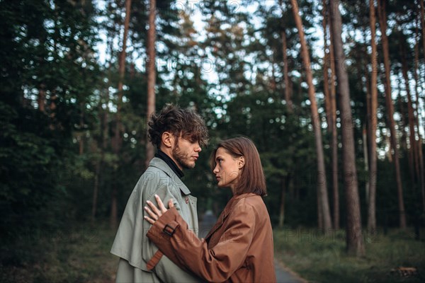 Romantic couple of lovers on a date in the park in cold weather. Fashionable couple in coat