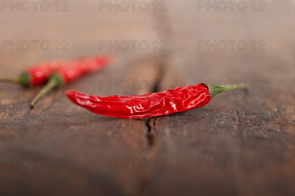 Dry red chili peppers over old wood table