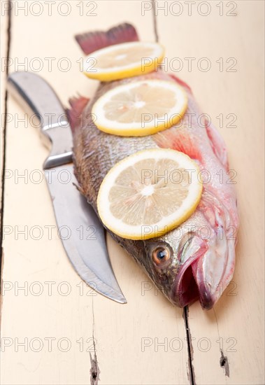 Fresh whole raw fish on a wooden table ready to cook