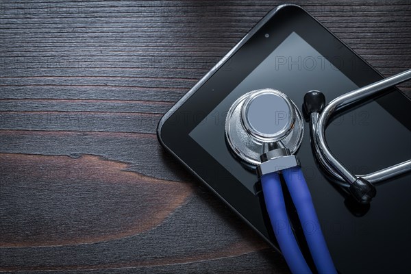 Horizontal version of stethoscope and tablet on vintage wooden background medicine concept