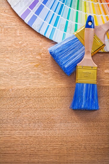 Multi coloured Pantone fan and brush on wooden board construction concept