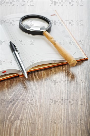 Pen and magnifying glass on the notebook