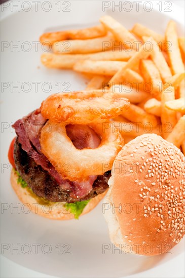 Classic american hamburger sandwich with onion rings and french fries