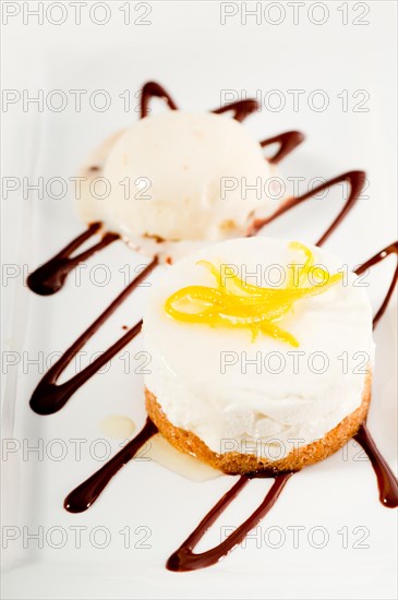 Very elegant lemon mousse dessert served whith lemon peel on top and vanilla ice cream on side