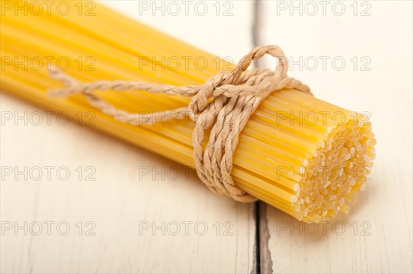 Italian pasta spaghetti tied with a rope on a rustic table