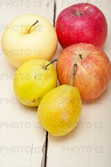 Fresh fruits apples and pears on a white wood table