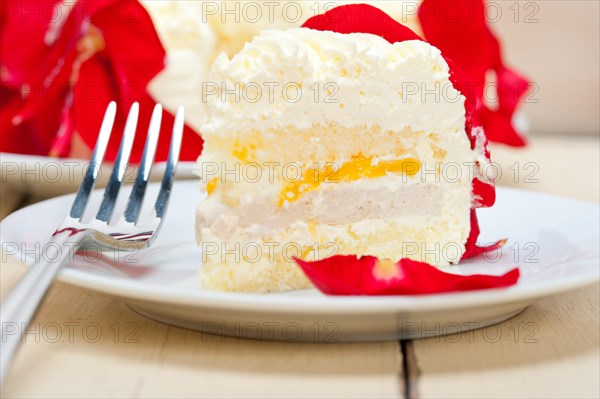 Whipped cream mango cake with red rose petals