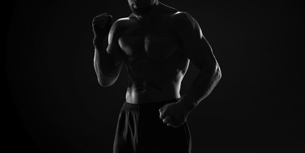 Noname image of a kickboxer on a dark background. The concept of mixed martial arts. MMA