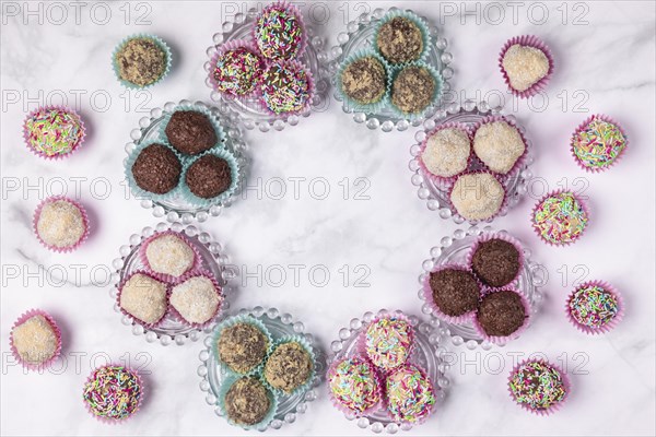 Light and dark rum balls arranged in a circle on and next to glass plates