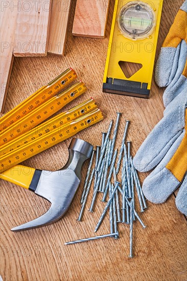 Carpenter's tools Nails Claw hammer Protective gloves Aligning boards on wooden plank