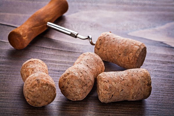 Corks from chmapagne and corkscrew on vintage wooden board alcohol concept