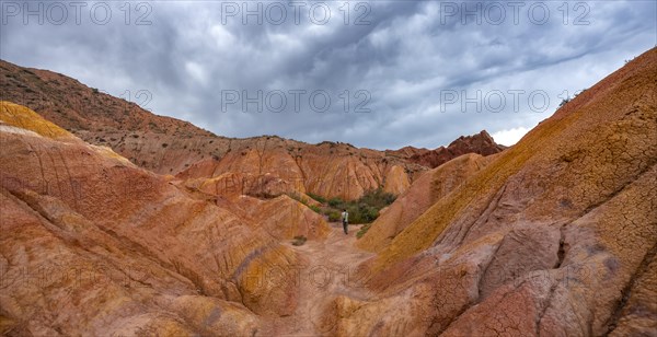 Tourist hikes through canyon of eroded sandstone formations