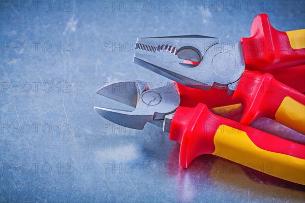Metal pliers nippers on metallic background electricity concept