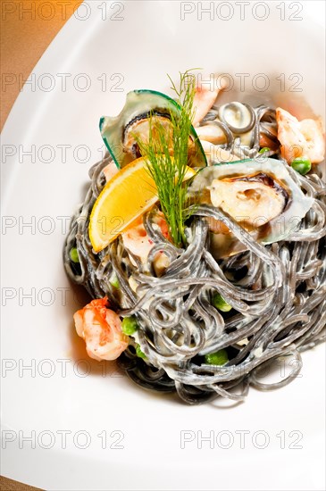 Fresh seafood black squid ink coulored spaghetti pasta tipycal italian food