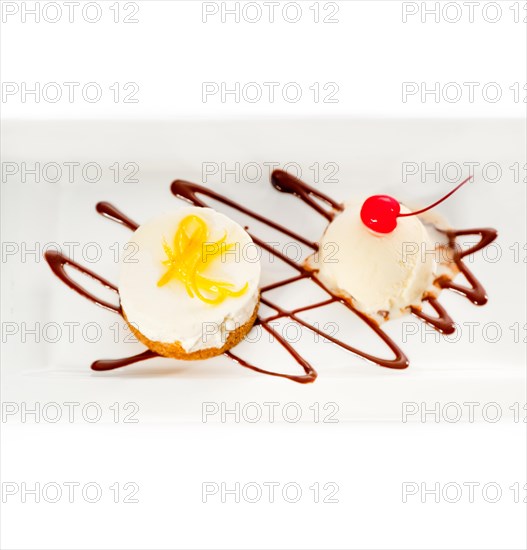 Very elegant lemon mousse dessert served whith lemon peel on top and vanilla ice cream on side