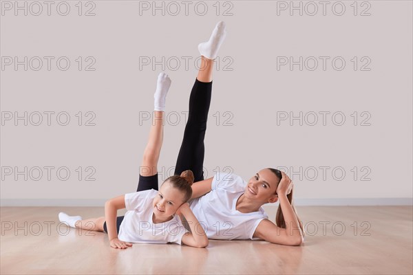 Beautiful female teacher poses with a little girl in a gymnastics class. The concept of education