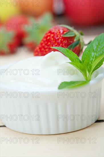 Organic Greek yogurt and strawberry over white rustic wood table