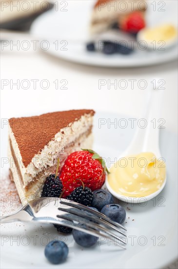 Classic Italian tiramisu dessert with berries and custartd pastry cream on side