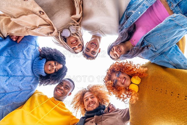 Low angle view of multi-ethnic people forming a circle and smiling at camera