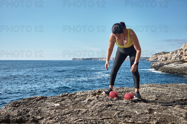 FITNESS LATIN WOMAN IN SPORTS SET TRAINING WITH ELASTIC BAND