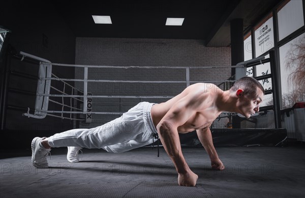 Muscular man doing push-ups in the gym. Fitness concept.