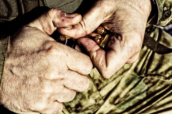 The fighter prepares a clip with bullets before the next fight.