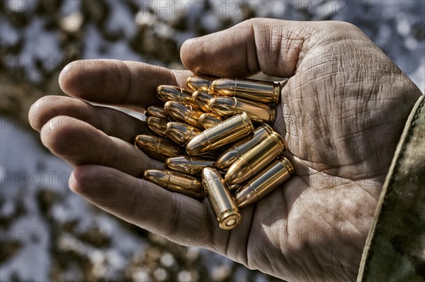 The fighter holds a handful of bullets in his palm for weapons.