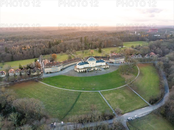 Aerial view of a spa building with neighbouring park in the evening