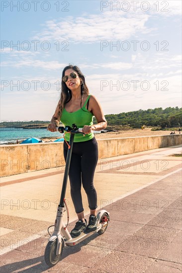 Young latin girl on electric scooters having fun on city street on a sunny summer day. Outdoor portrait girl riding electric scooter in the park