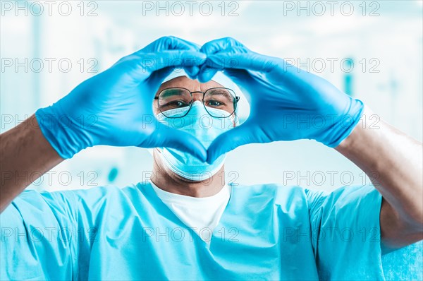 Portrait of a doctor in a hospital. He folded his hands in the shape of a heart. Medicine concept.