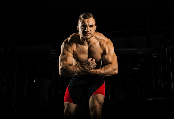 The weightlifter is posing in front of the camera