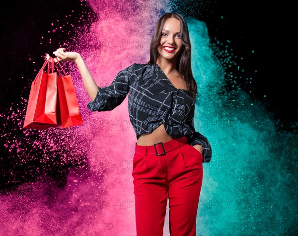 Beautiful happy brunette with red packages in her hands. Concept for discounts